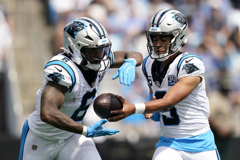 Carolina Panthers quarterback Bryce Young hands off to running back Miles Sanders during the first half of an NFL football game against the Los Angeles Chargers on Sunday, Sept. 15, 2024, in Charlotte, N.C. (AP Photo/Erik Verduzco)