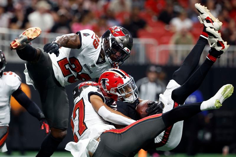 Atlanta Falcons wide receiver Darnell Mooney (1) makes a touchdown reception between Tampa Bay Buccaneers cornerback Zyon McCollum (27) and safety Christian Izien (29) during the first half of an NFL football game Thursday, Oct. 3, 2024, in Atlanta. (AP Photo/Butch Dill)