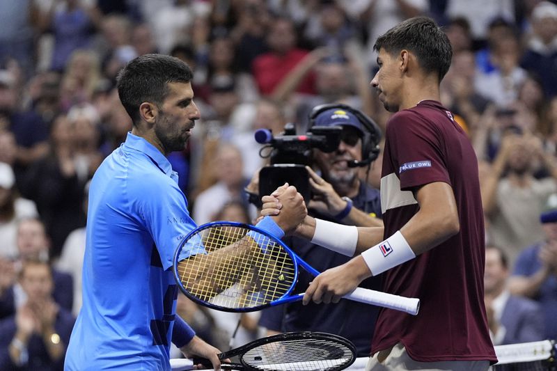 Novak Djokovic, of Serbia, shakes hands with Alexei Popyrin, of Australia, during a third round match of the U.S. Open tennis championships, Friday, Aug. 30, 2024, in New York. (AP Photo/Julia Nikhinson)