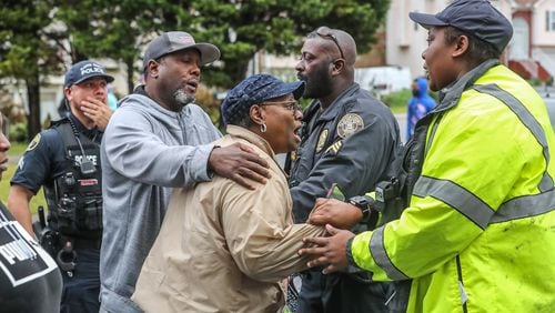 A woman, who declined to be identified, screams at Clayton County police, “You killed my husband,” as officers speak to her near the scene where the man was shot and killed Wednesday morning.