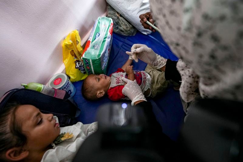 A health worker administers a polio vaccine to a child at a hospital in Khan Younis, Saturday, Aug. 31, 2024. (AP Photo/Abdel Kareem Hana)