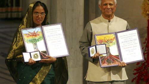 FILE- Nobel Peace Prize winners Muhammad Yunus, right, and Grameen Bank representative Mosammat Taslima Begum display their medals and diplomas at City Hall in Oslo, Norway Sunday Dec. 10, 2006. (AP Photo/John McConnico, File)