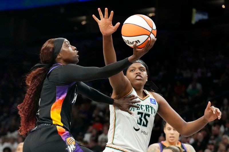 Phoenix Mercury guard Kahleah Copper, left, drives past New York Liberty forward Jonquel Jones (35) to score during the second half of a WNBA basketball game Monday, Aug. 26, 2024, in Phoenix. (AP Photo/Ross D. Franklin)