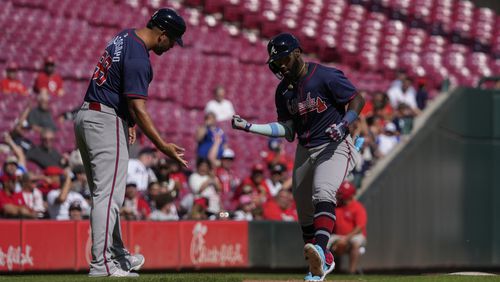 Atlanta Braves' Michael Harris II, right, celebrates with third base coach Matt Tuiasosopo, left, after hitting a solo home run during the eighth inning of a baseball game against the Cincinnati Reds, Thursday, Sept. 19, 2024, in Cincinnati. (AP Photo/Joshua A. Bickel)