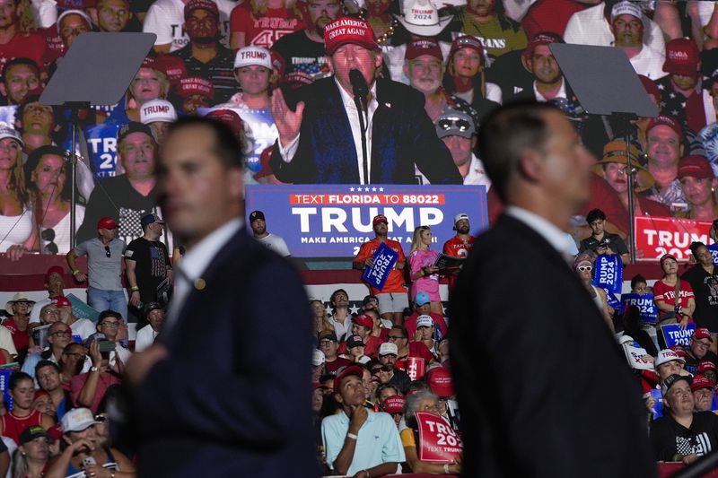 U.S. Secret Service agents watch as am image of Republican presidential candidate former President Donald Trump is shown on a screen at a campaign rally at Trump National Doral Miami, Tuesday, July 9, 2024, in Doral, Fla. (AP Photo/Rebecca Blackwell)