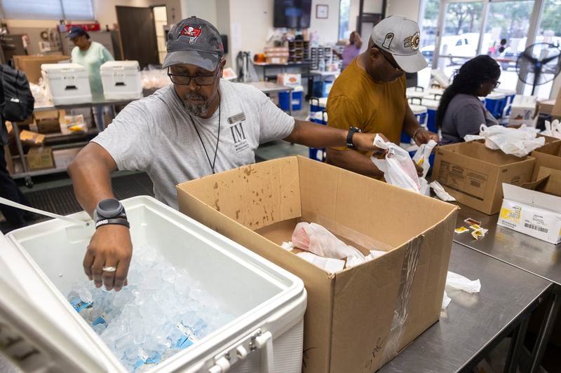 Warehouse Specialist David Callwood grabs cold cartons of milk for Meals on Wheels clients, Friday, July 12, 2024, in Houston. (AP Photo/Annie Mulligan)