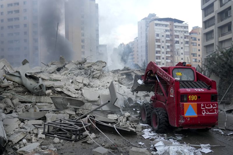 Civil Defense remove debris from a destroyed complex hit in Israeli airstrikes in Dahieh, Beirut, Lebanon, Wednesday, Oct. 2, 2024. (AP Photo/Hussein Malla)