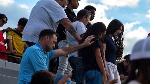 Families bow their heads in prayer. Hundreds gather at Flowery Branch High School  to celebrate the life of Ricky Aspinwall II. Sunday, Sept. 8, 2024. Richard Aspinwall, a football assistant coach and teacher at Apalachee High School in Barrow County, was one of four people killed in the Sept. 4 school shooting.  (Ben Hendren for The Atlanta Journal-Constitution)