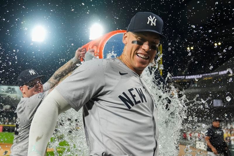 New York Yankees' Aaron Judge is doused by his teammates after he hit his 300th career home run, the fastest player to do so in MLB history, in a baseball game against the Chicago White Sox, Wednesday, Aug. 14, 2024, in Chicago. (AP Photo/Erin Hooley)