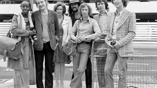 FILE - The Blue Mink pop group including Roger Cook, wearing hat, Madeline Bell, left, and bass player Herbie Flowers, second right, leaving London for Los Angeles, and the start of a two week tour on July 1973. Flowers, who played with David Bowie, Elton John, Lou Reed and other music legends in a decades-long career, has died at 86. (PA via AP, File)