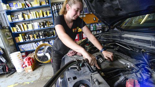 FILE - Elise Lacroix, owner of Stop & Go in Brattleboro, Vt., changes the oil on a vehicle at her shop on July 15, 2024. (Kristopher Radder/The Brattleboro Reformer via AP, File)