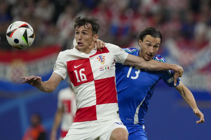 Croatia's Ante Budimir, left, vies for the ball with Italy's Matteo Darmian during a Group B match between Croatia and Italy at the Euro 2024 soccer tournament in Leipzig, Germany, Monday, June 24, 2024. (AP Photo/Sunday Alamba)
