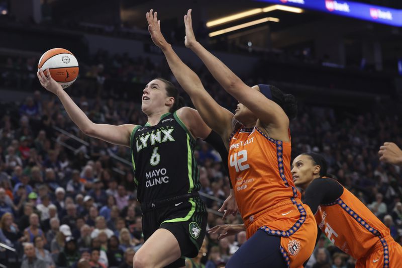 Minnesota Lynx forward Bridget Carleton (6) jumps up to the basket against Connecticut Sun forward Brionna Jones (42) during the first half of Game 1 of a WNBA basketball semifinals series Sunday, Sept. 29, 2024, in Minneapolis. (AP Photo/Stacy Bengs)