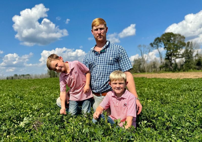 Peanut farmer Riley Davis in a peanut field south of Plains with his sons, Drew (left, 4) and Luke, 7.