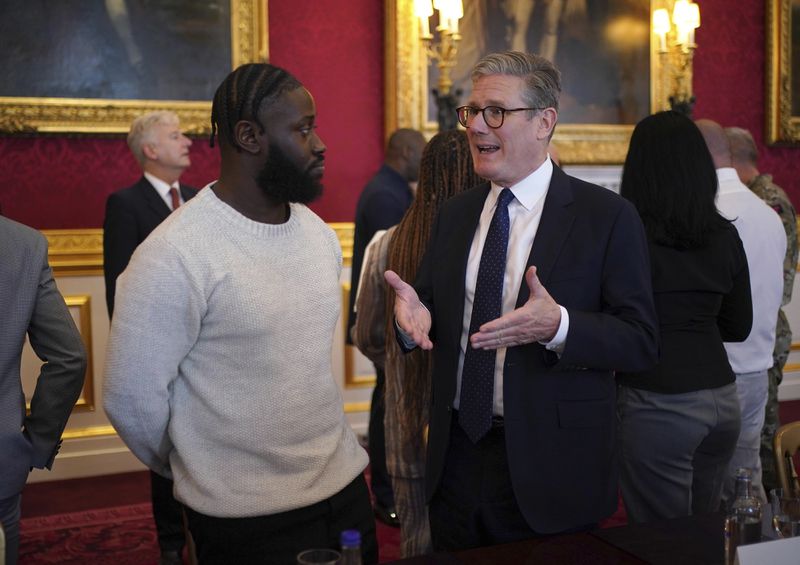 Prime Minister Sir Keir Starmer, right, speaking to Gideon Buabeng at an event for The King's Trust to discuss youth opportunity, at St James's Palace in central London, Friday July 12, 2024. The King and Mr Elba, an alumnus of The King's Trust (formerly known as The Prince's Trust), are meeting about the charity's ongoing work to support young people, and creating positive opportunities and initiatives which might help address youth violence in the UK, as well as the collaboration in Sierra Leone between the Prince's Trust International and the Elba Hope Foundation. (Yui Mok/pool photo via AP)