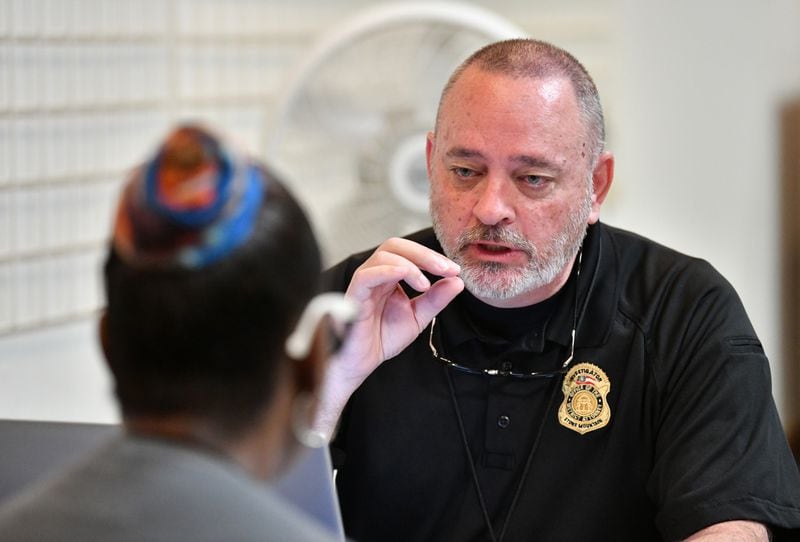 James Delk, an investigator with the DeKalb County District Attorney's Office, speaks with a family member of a missing person during a "DNA Drive" in 2023. Families were invited to donate DNA that may help identify their loved ones.