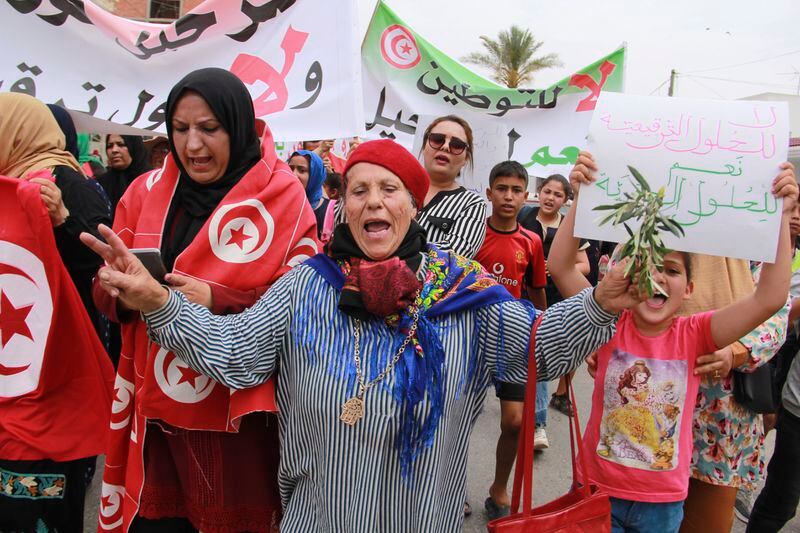 Tunisians take part in a protest against the presence of sub-Saharan migrants who have found themselves stranded as the country ramps up its border patrol efforts, in Jebeniana, Tunisia, Saturday, May 18, 2024. Anti-migrant anger is mounting in olive-growing towns along the Tunisian coastline that have emerged as a launchpad for thousands of people hoping to reach Europe by boat. (AP Photo/Houssem Zouari)