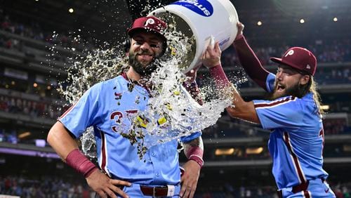 Philadelphia Phillies' Weston Wilson, center, is doused by teammates Brandon Marsh, right, and Bryson Stott after a victory over the Washington Nationals in a baseball game, Thursday, Aug. 15, 2024, in Philadelphia. (AP Photo/Derik Hamilton)