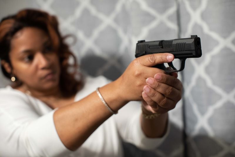 Shanique Shaw poses for a photo with her new handgun at her home, Wednesday, Jan. 27, 2021, in Austell, Ga.  BRANDEN CAMP FOR THE ATLANTA JOURNAL-CONSTITUTION 