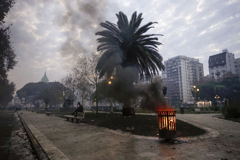 A trash bin burns following clashes between anti-government protesters and police outside Congress, where lawmakers debate a reform bill promoted by Argentine President Javier Milei in Buenos Aires, Argentina, Wednesday, June 12, 2024. (AP Photo/Natacha Pisarenko)
