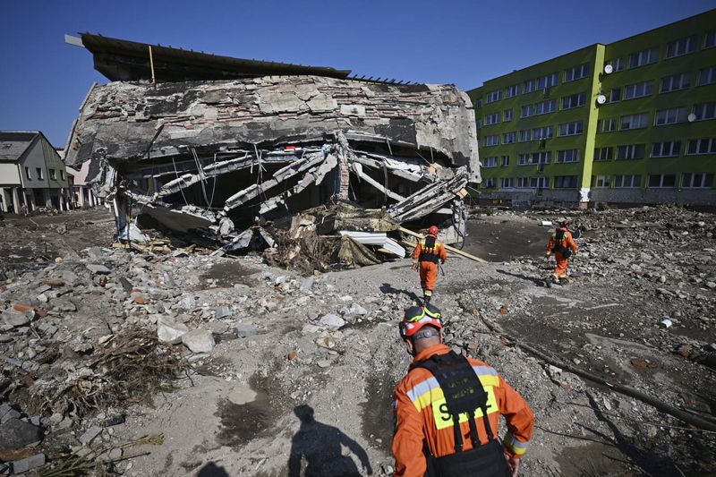 On this handout photo provided by the State Fire Service of Poland, firefighters inspecting safety of houses following heavy flooding in the town of Stronie Slaskie, southwestern Poland, Wednesday, Sept. 18, 2024. (Tomasz Fijołek/KG PSP via AP)