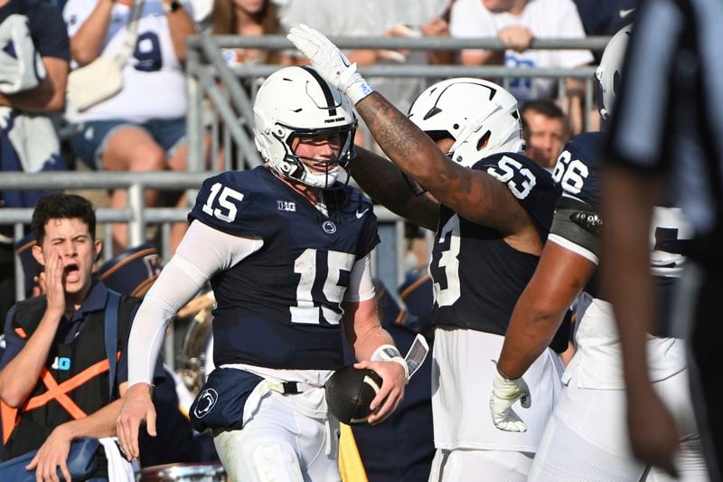 Penn State quarterback Drew Allar (15) celebrates after a touchdown run with offensive lineman Nick Dawkins (53) during the second quarter of an NCAA college football game against Kent State, Saturday, Sept. 21, 2024, in State College, Pa. (AP Photo/Barry Reeger)