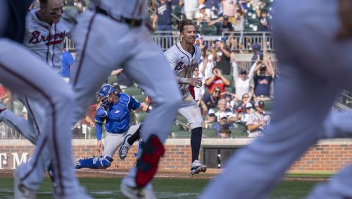 Atlanta Braves' Eli White, center, celebrates after scoring the winning run in the 11th inning of a baseball game against the Toronto Blue Jays, Sunday, Sept. 8, 2024, in Atlanta. (AP Photo/Erik Rank)