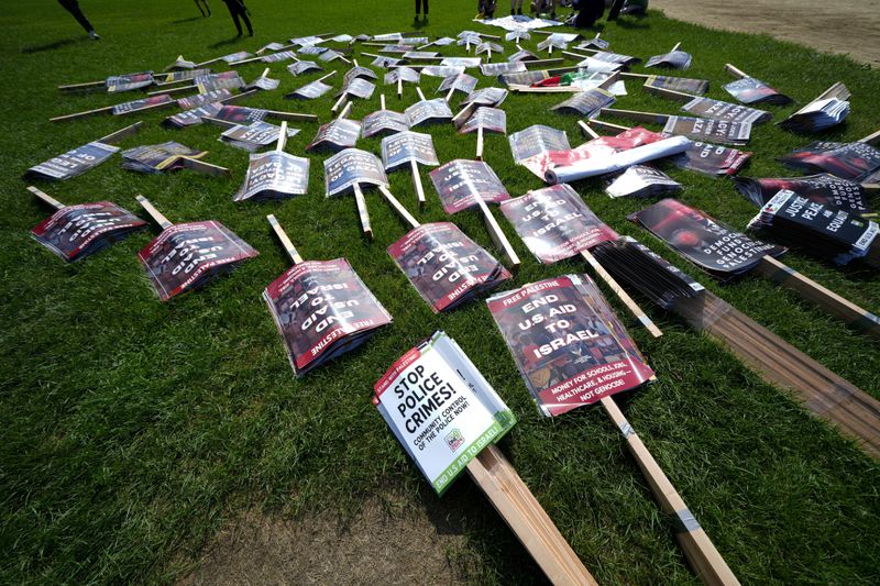 Protest signs are set out prior to a demonstration at Union Park during the Democratic National Convention Monday, Aug. 19, 2024, in Chicago. (AP Photo/Julio Cortez)