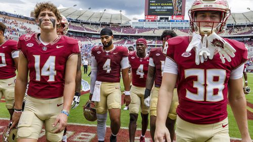 Florida State quarterbacks Luke Kromenhoek (14), DJ Uiagalelei (4), defensive back Charles Lester III (4) and defensive back Cade Papineau (38) walk off the field after losing 20-12 to Memphis in an NCAA college football game, Saturday, Sept. 14, 2024, in Tallahassee, Fla. (AP Photo/Colin Hackley)