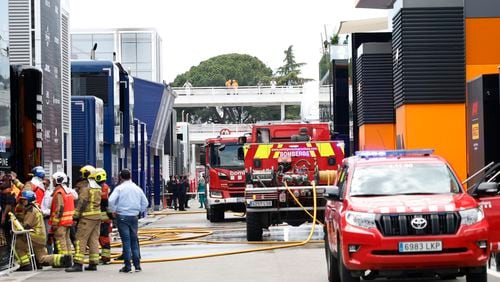 Firefighters work in the paddock after the McLaren F1 team were forced to evacuate its hospitality suite due to a fire during the 3rd practice session for the Formula 1 Spanish Grand Prix at the Barcelona Catalunya racetrack in Montmelo, near Barcelona, Spain, Saturday, June 22, 2024. The British team says there were no injuries. (AP Photo/Joan Monfort)