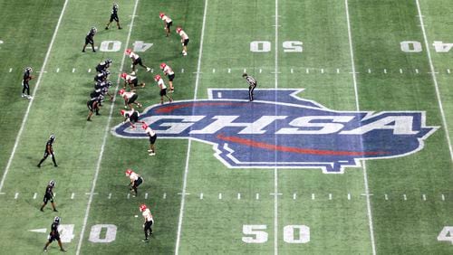 The Cedar Grove offense prepares for a play against the Savannah Christian defense near the GHSA logo at midfield during the Class 3A GHSA State Championship game at Mercedes-Benz Stadium, Wednesday, December. 13, 2023, in Atlanta. (Jason Getz / Jason.Getz@ajc.com)