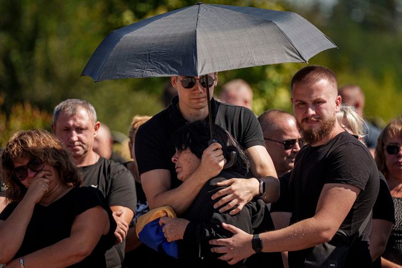 Relatives and friends react during the funeral ceremony of Ukrainian servicemen killed in a Russian rocket attack at a Ukrainian military academy, in Poltava, Ukraine, Saturday Sept. 7, 2024. (AP Photo/Evgeniy Maloletka)