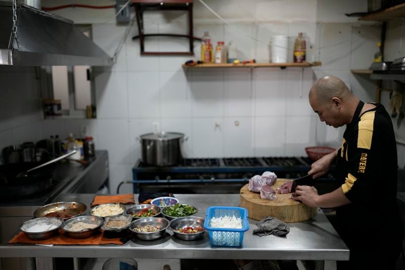 Li Ming prepares food at his son's Chinese food restaurant “Nueve y media,” in the Roma Sur neighborhood of Mexico City, Friday, July 5, 2024. (AP Photo/Eduardo Verdugo)