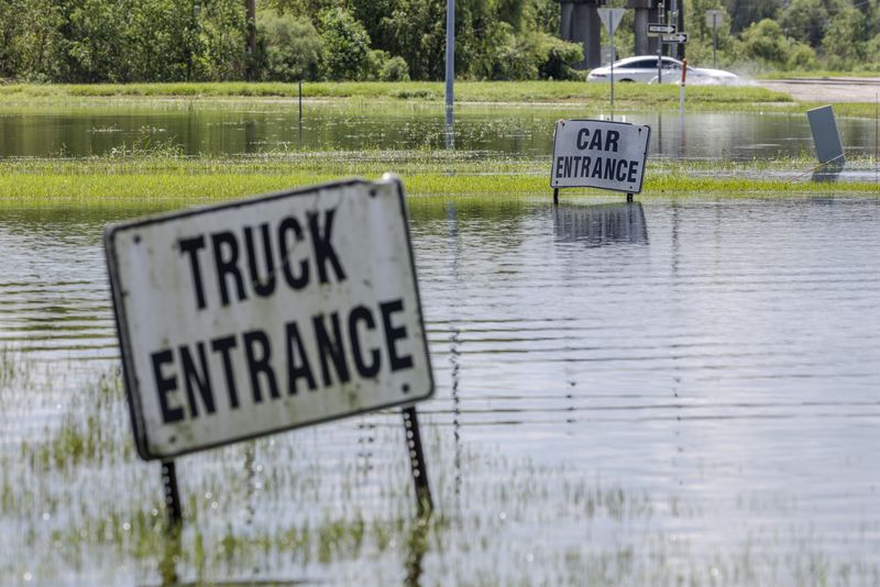 Cars drive off of Interstate 10 in Laplace, La., on Friday, Sept. 13, 2024, as floodwater still covers the roadway two days after Hurricane Francine swept through the area. (Chris Granger/The Times-Picayune/The New Orleans Advocate via AP)