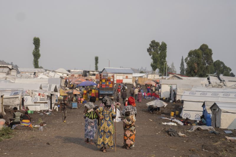 Women walk in the Bulengo refugee camp in Goma, Congo, after the World Health Organization had declared Thursday, Aug, 15, 2024, the increasing spread of mpox in Africa a global health emergency, warning the virus might ultimately spill across international borders. (AP Photo/Moses Sawasawa)