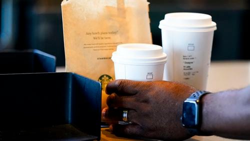 FILE - A customer picks up a drink at a Starbucks on June 28, 2023, in Seattle.(AP Photo/Lindsey Wasson, File)