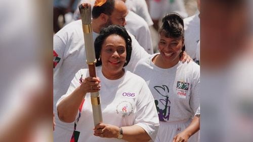 Coretta Scott King (with daughter Bernice King and son Martin Luther King III by her side) carries the Olympic torch prior to the start of the 1996 Olympic Games in Atlanta.