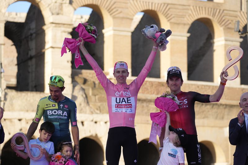 From left, second classified Colombia's Daniel Felipe Martinez, first classified Slovenia's Tadej Pogacar and third classified Britain's Geraint Thomas celebrate during the podium ceremony at the end of the 21st and last stage of the Giro D'Italia, tour of Italy cycling race, in Rome, Sunday, May 26, 2024. (AP Photo/Andrew Medichini)
