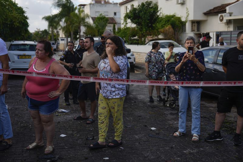 People look at the site hit by a rocket fired from Lebanon, in Kiryat Bialik, northern Israel, on Sunday, Sept. 22, 2024. (AP Photo//Ariel Schalit)