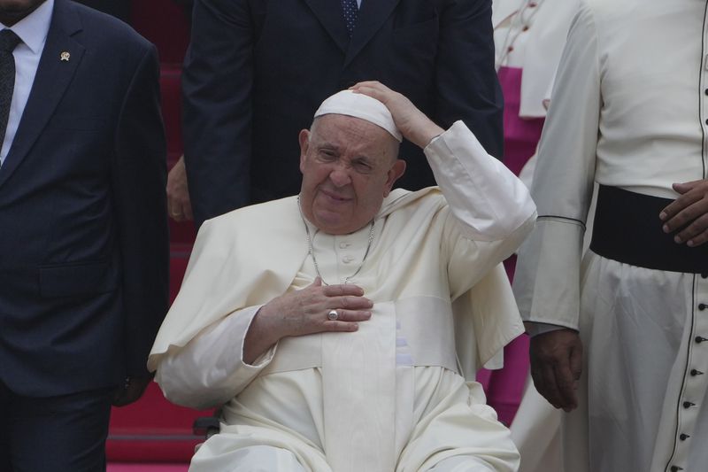 Pope Francis on his wheelchair, holds his cap upon arrival during an official welcoming ceremony at Soekarno-Hatta International Airport in Tangerang on the outskirts of Jakarta, Indonesia, Tuesday, Sept. 3, 2024. (AP Photo/Achmad Ibrahim)