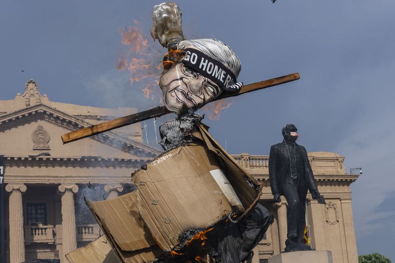 Protestors burn an effigy of acting President and Prime Minister Ranil Wickremesinghe as they demand his resignation in Colombo, Sri Lanka, Tuesday, July 19, 2022. (AP Photo/Rafiq Maqbool, File)