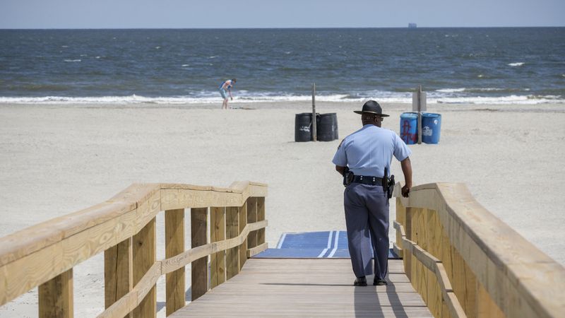 TYBEE ISLAND, GA - APRIL 4, 2020: Georgia State Patrol Capt. Thornell King watches visitors to Tybee Island beach after Gov. Brian Kemp signed an executive order allowing people to exercise outside, with social distancing of at least 6 feet. (AJC Photo/Stephen B. Morton)