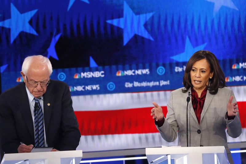 FILE - Democratic presidential candidate Sen. Kamala Harris, D-Calif., speaks as Democratic presidential candidate Sen. Bernie Sanders, I-Vt., takes notes during a Democratic presidential primary debate, Nov. 20, 2019, in Atlanta. (AP Photo/John Bazemore, File)