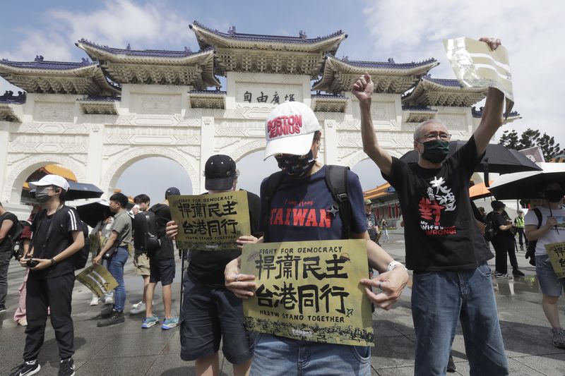Hong Kong activists and supporters in Taiwan hold a protest commemorating the 10th anniversary of the 2014 umbrella movement and the fifth anniversary of the anti-extradition law amendment bill movement in Taipei, Taiwan, Sunday, June 9, 2024. Banners read " Fight for democracy, Hong Kong and Taiwan stand together. " (AP Photo/Chiang Ying-ying)