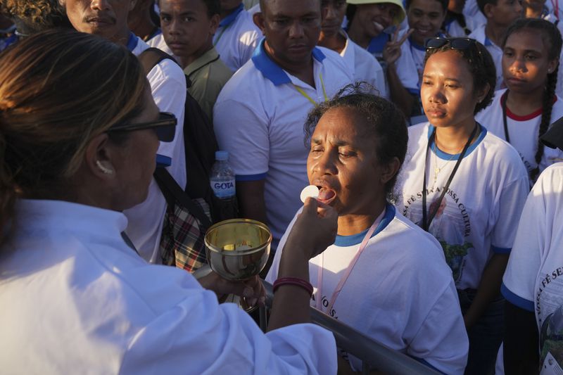 Faithful receive communion during the holy mass lead by Pope Francis at Tasitolu park in Dili, East Timor, Tuesday, Sept. 10, 2024. (AP Photo/Dita Alangkara, Pool)