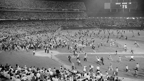 FILE - Fans pour onto the field at the Oakland Coliseum after the Oakland A's beat the Los Angeles Dodgers 3-2 and won their third straight World Series, Oct. 17, 1974, in Oakland. (AP Photo, File)