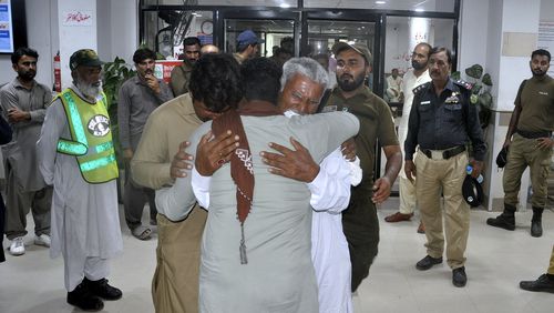 Family members of police officers, who were killed in gunmen ambush on a police convoy in a deserted area, mourn at a hospital in Rahim Yar Khan, Pakistan, Friday, Aug. 23, 2024. (AP Photo/Saddique Baloch)