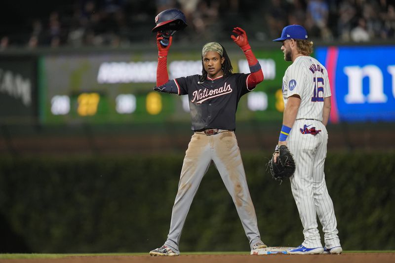 Washington Nationals' CJ Abrams, left, does a little dance toward his dugout next to Chicago Cubs first baseman Patrick Wisdom after Abrams hit a double during the third inning of a baseball game against the Chicago Cubs, Thursday, Sept. 19, 2024, in Chicago. (AP Photo/Erin Hooley)