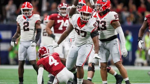 Georgia Bulldogs defensive lineman Warren Brinson (97) reacts with Georgia defensive lineman Tyrion Ingram-Dawkins (93) after tackling Alabama Crimson Tide quarterback Jalen Milroe (4) during the first half of the SEC Championship football game at the Mercedes-Benz Stadium in Atlanta, on Saturday, December 2, 2023. (Jason Getz / Jason.Getz@ajc.com)