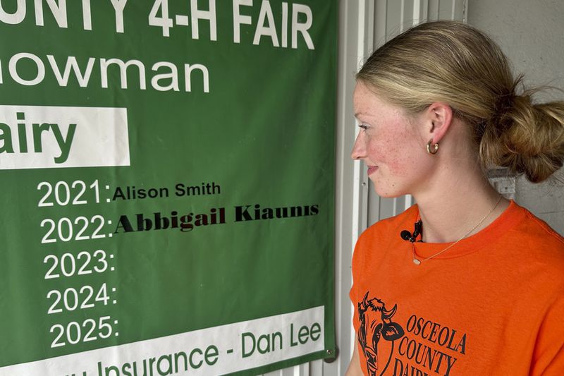 Osceola County 4-H member Alison Smith stands inside the dairy barn Thursday, Aug. 1, 2024, at the county fairgrounds in Evart, Mich. (AP Photo/Mike Householder)